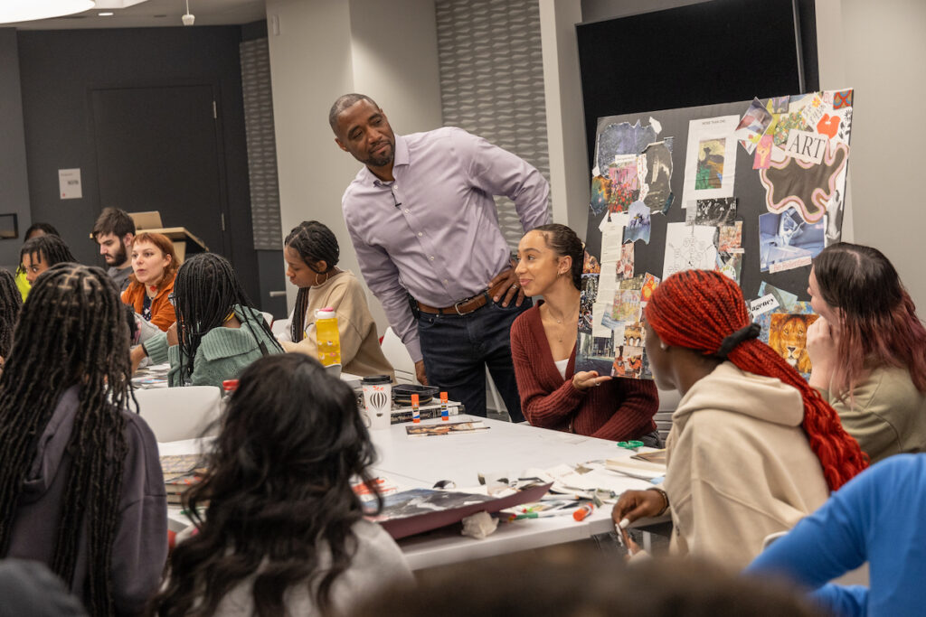 CJ Gross, author of ''What’s Your Zip Code Story?'', admires a collage created by college students from the University of Arts and high school students from the Revolution School who collaborated to create art reflecting on race, class and equity on Oct. 10, 2023