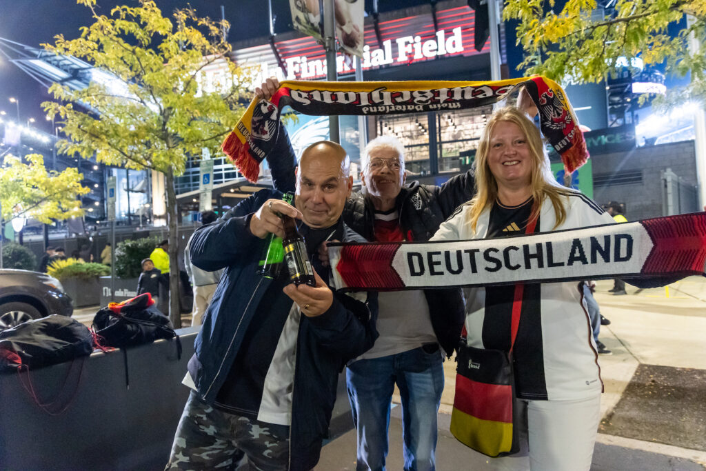 Fans hold up Germany National Team merch outside of Lincoln Cinancial Field