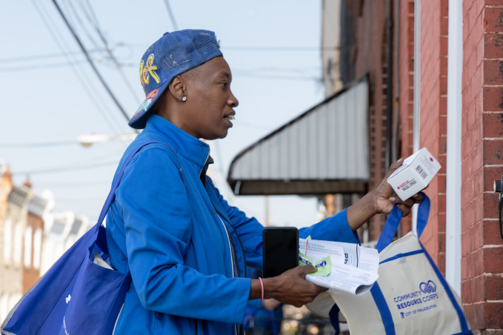 10 19 2023 k paynter opioid crisis canvassing-4 Marsella Elie, a canvasser for Philly Counts, gives opioid overdose reverse drug Narcan to a North Philadelphia resident as part of an initiative with the city’s Office of Community Empowerment and Opportunity to get harm reduction resources into homes in areas heavily hit by the opioid crisis. (Kimberly Paynter/WHYY)