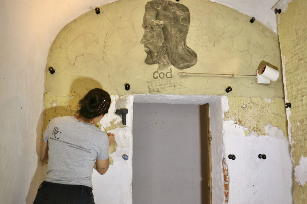 Gabriela Genao works to restore a wall.