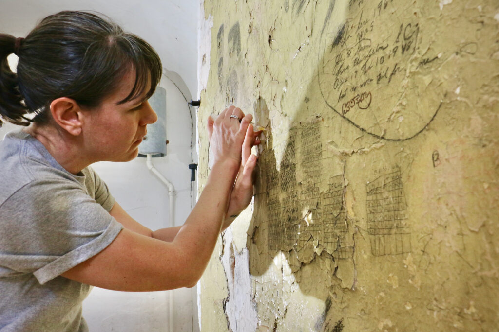 Meris Westberg works to restore a wall