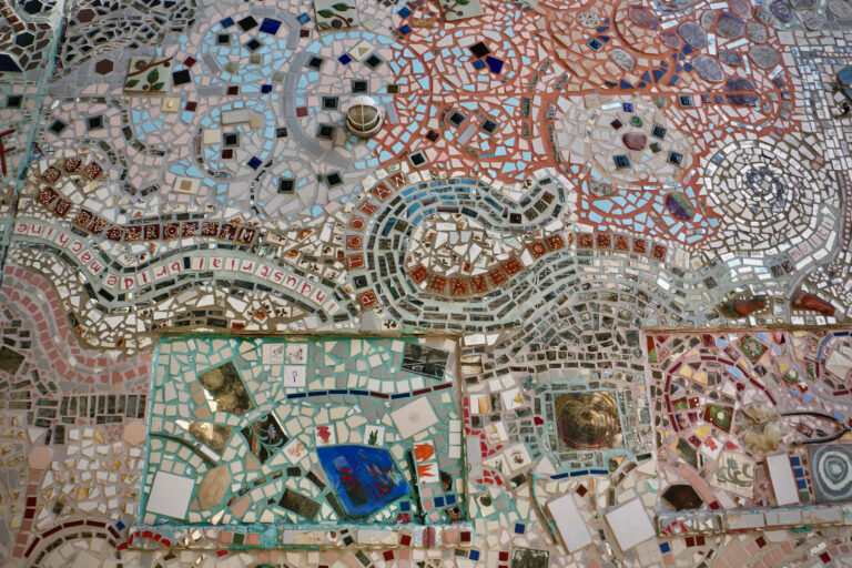 A large colorful mosiac on the side of a building.