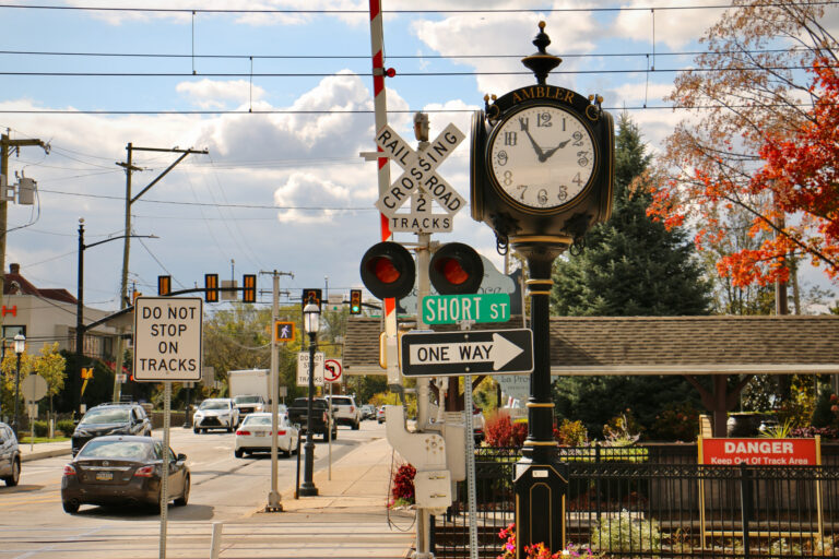 SEPTA railroad crossing signs with cars on a road in the background.