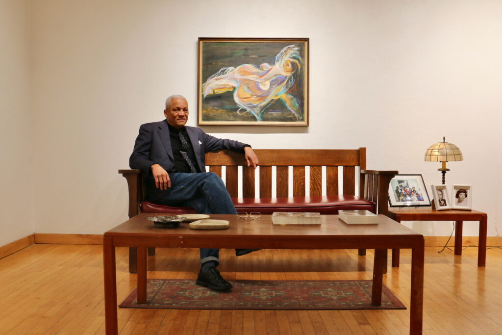2023 10 19-e lee-mark rollins-philadelphia fleisher art memorial-dox thrash Mark Rollins sitting on a bench. A Dox Thrash painting in the background.