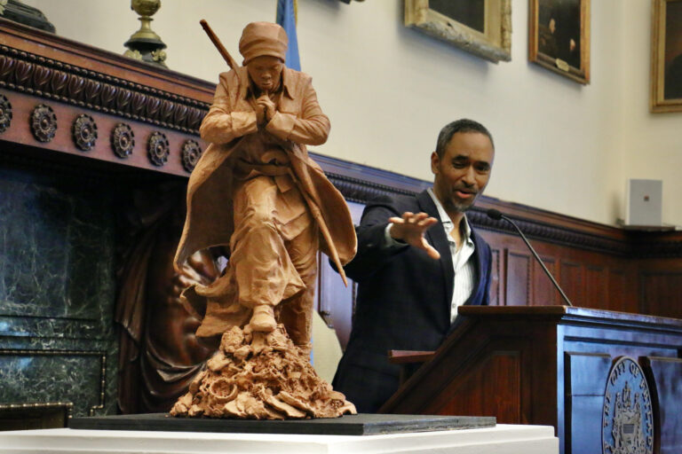 Artist Alvin Pettit talks in the background. In the foreground is his design for the Harriet Tubman statue.