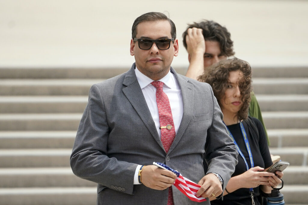 George Santos File photo: U.S. Rep. George Santos, R-N.Y., holds a miniature American flag that was presented to him as he departs federal court, June 30, 2023, in Central Islip, N.Y.