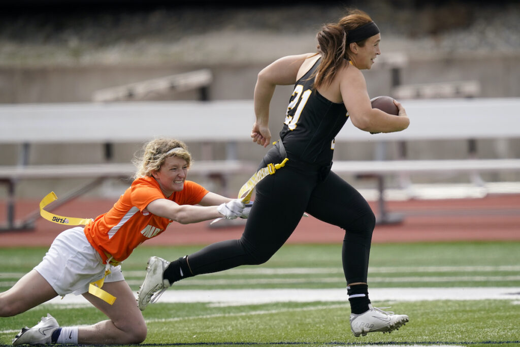 Madysen Carrera, Casey Thompson File photo: Ottawa quarterback Madysen Carrera (21) is tackled by Midland defender Casey Thompson (left) during an NAIA flag football game in Ottawa, Kan., March 26, 2021.