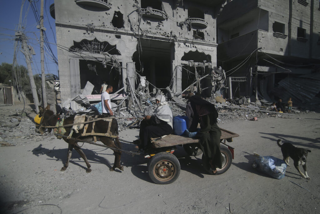 APTOPIX Israel Palestinians Palestinians leave their houses following Israeli airstrikes in Rafah refugee camp, southern Gaza Strip, Thursday, Oct. 12, 2023.