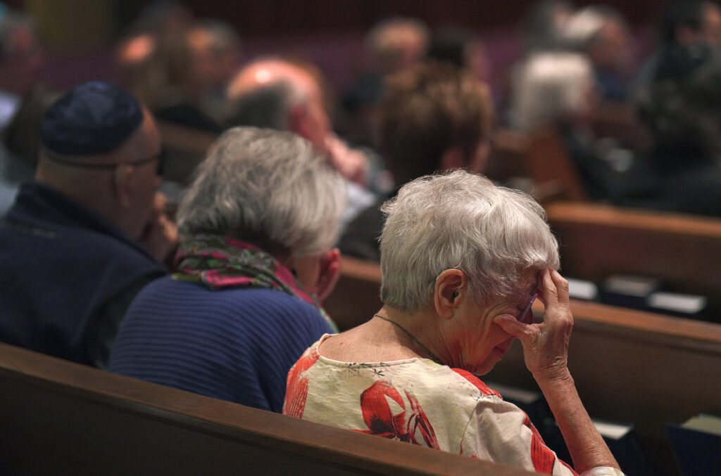 Anne Faigen, right, says a silent prayer for her friends in Israel while at a Shabbat service at Temple Sinai in Pittsburgh