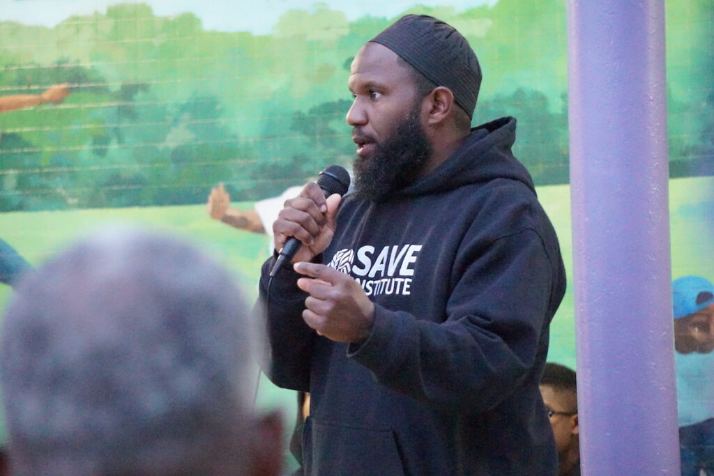 Atiba Jones speaks into a microphone