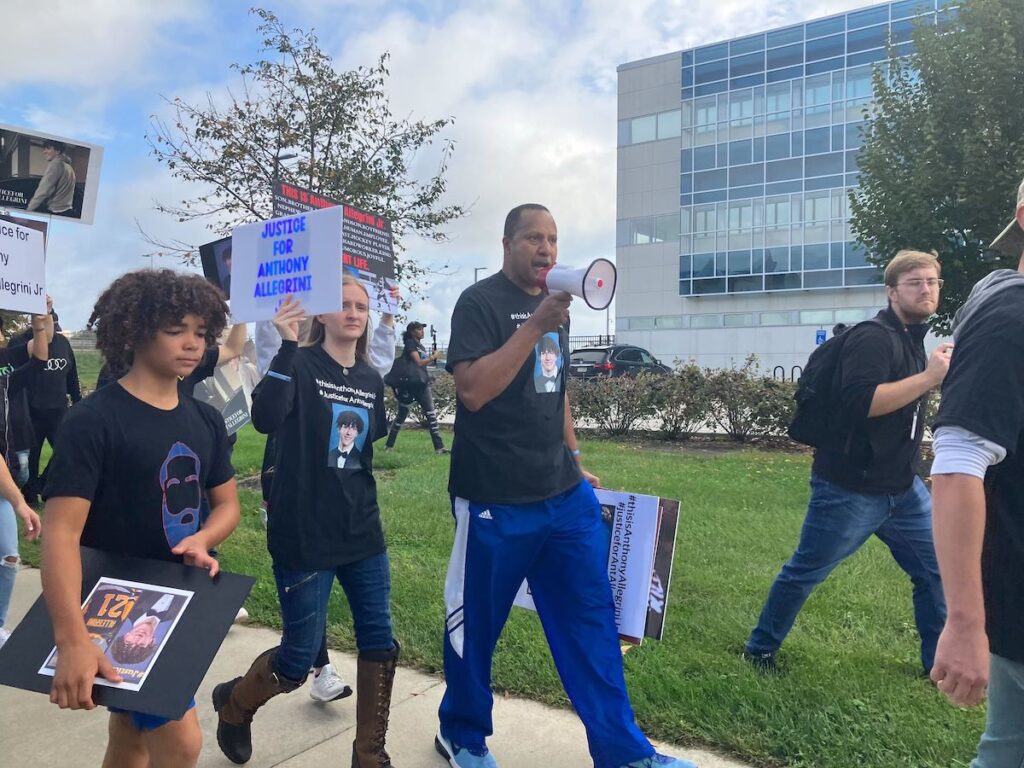 Terence Jones, an independent investigator who has been working with the Allegrini family, leads the crowd in a chant