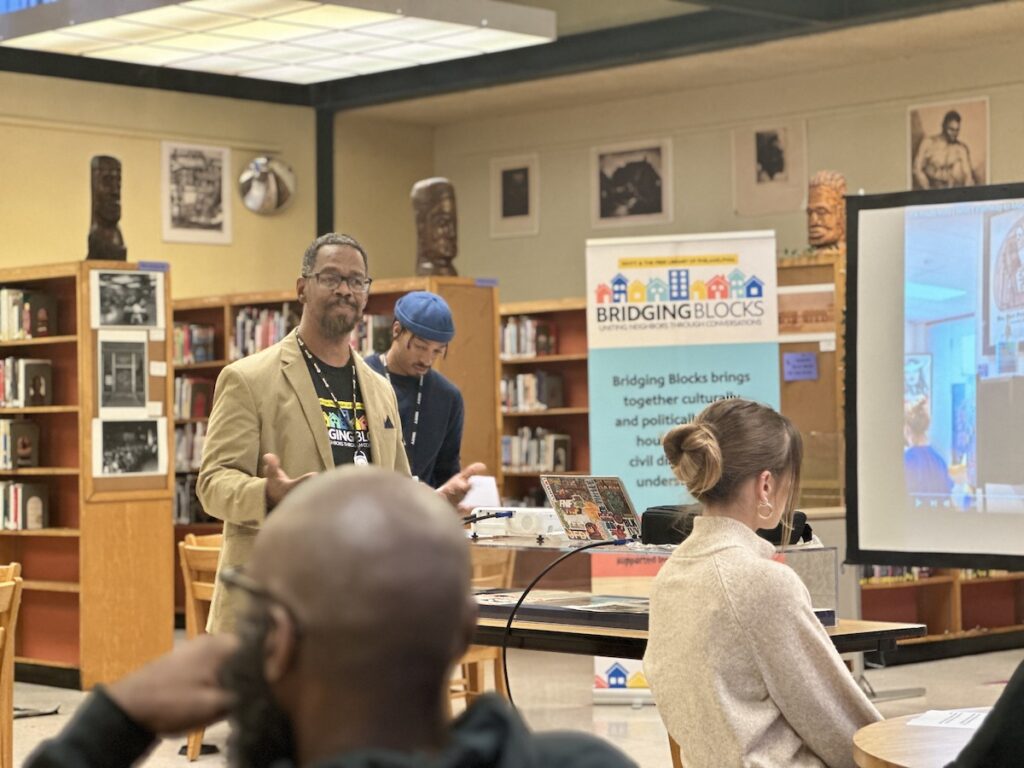 N.I.C.E. manager Eric Marsh Sr. and Amir Richardson speak at the front of the room as participants sit in seats