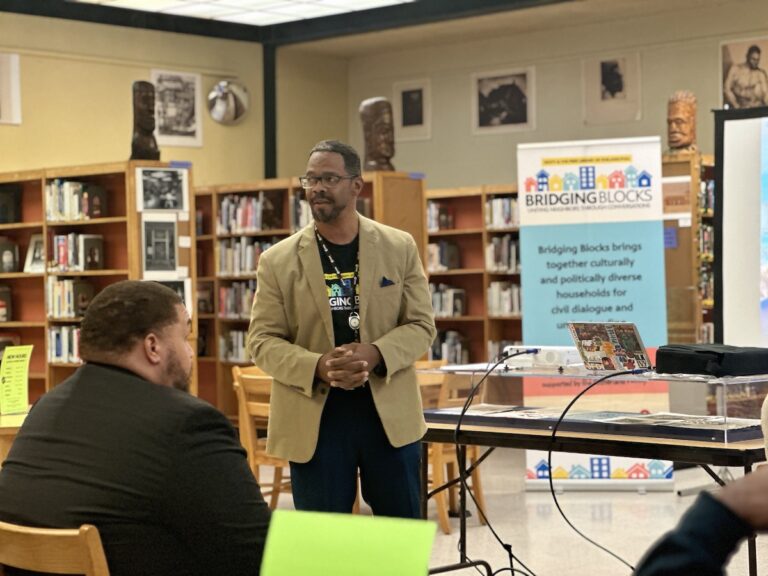 Eric Marsh Sr. speaks at the front of the room.