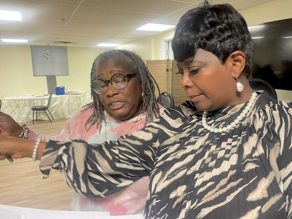 Jena Carter and Zanthia Oliver reading paperwork together.