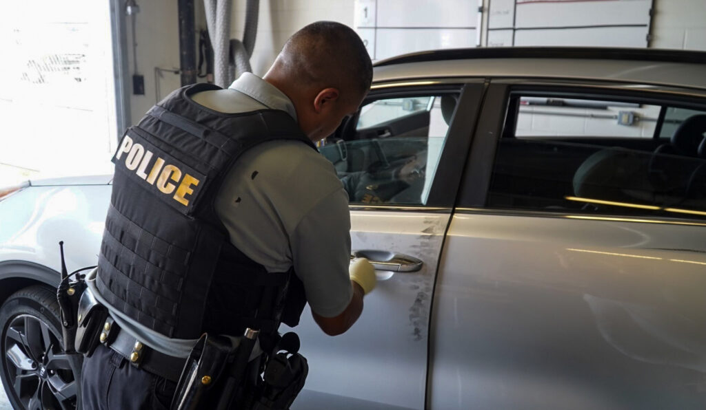 delaware-stolen-car-inspection-102423 A New Castle County police officer processes a recovered stolen care in search of evidence.