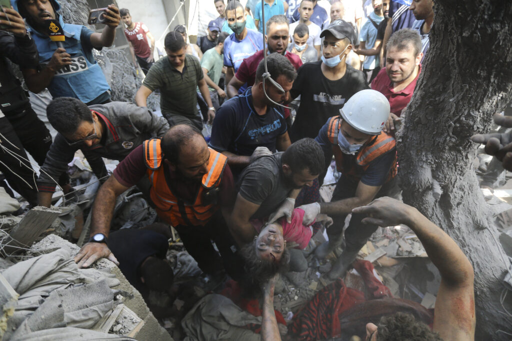 APTOPIX Israel Palestinians Palestinians rescue a child from under the rubble after Israeli airstrikes in Gaza City