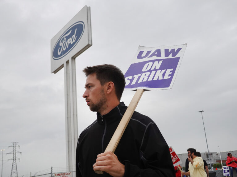 A person holds a sign that reads UAW on strike
