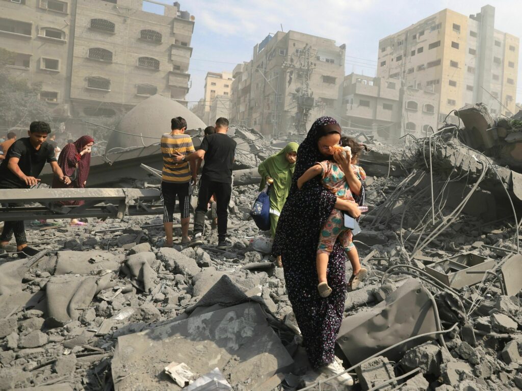 Palestinians evacuate the area following an Israeli airstrike on the Sousi mosque in Gaza City on October 9, 2023. Carnage after an airstrike