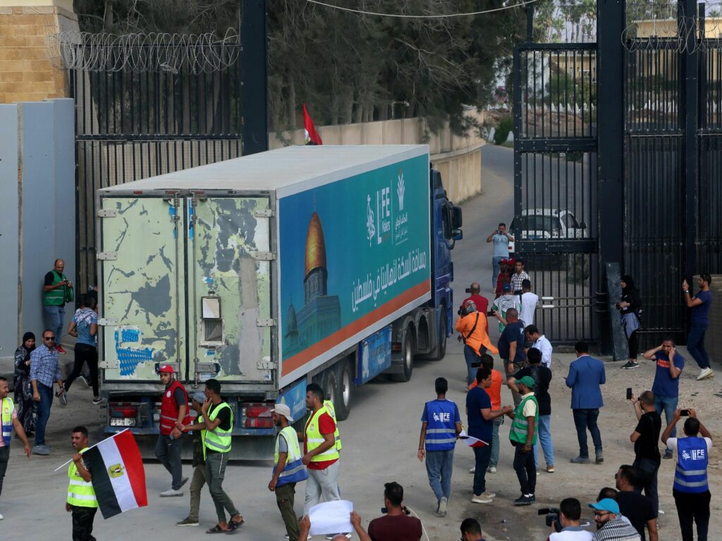 People on the Egyptian side of the Rafah border crossing watch as a convoy of lorries carrying humanitarian aid crosses to the Gaza Strip on Sunday. People on the Egyptian side of the Rafah border crossing watch as a convoy of lorries carrying humanitarian aid crosses to the Gaza Strip on Sunday.(Mohammed Assad/AFP via Getty Images)