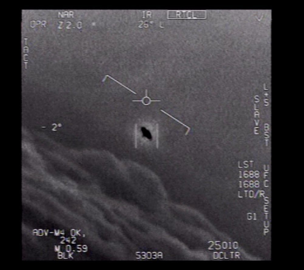 An unknown flying object flies against the wind in a greyscale video.