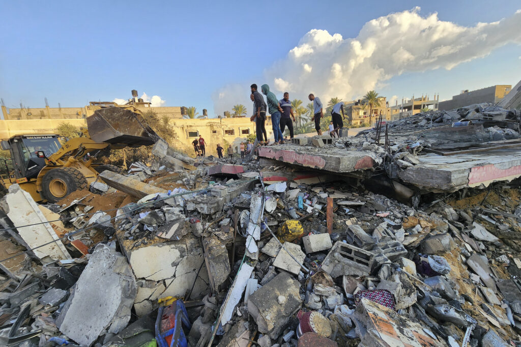 Palestinians Israel Palestinians stand by the rubble of a building destroyed in Israeli airstrikes in Deir el-Balah Gaza Strip