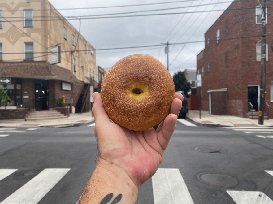 korshakbagel-street Philip Korshak holds up a bagel in one of his signature social media posts. The shop was the only independent cafe in Philly so far working under a ratified Local 80 union contract