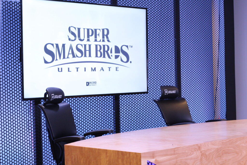 Desk with a sign behind it reads Super Smash Bros.