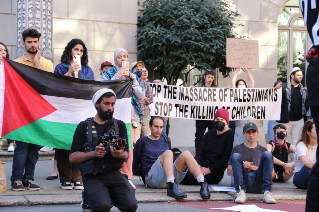 palestinian-supporters-protest-c-sharber-2023-10-1 Protesters holding signs and Palestinian flag at the rally.