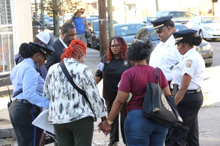 Councilmember Kenyatta Johnson stands in a circle with other people holding hands.