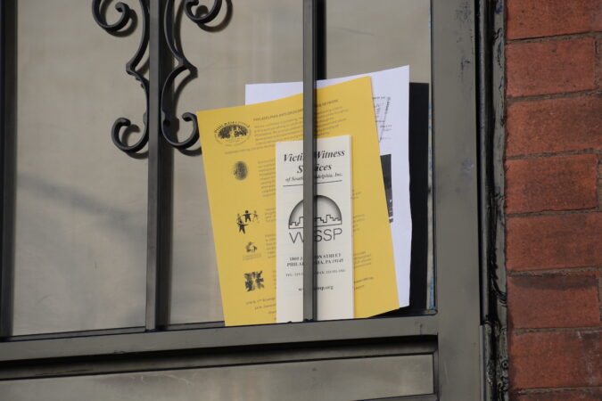 A flyer in a window grate is visible
