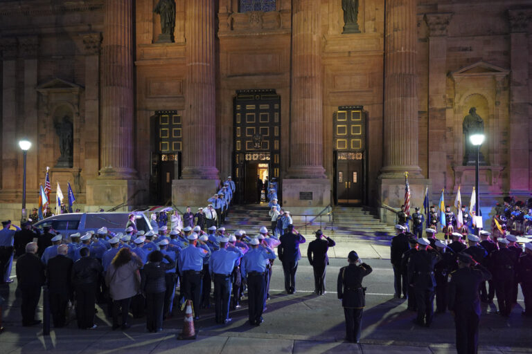 Officers salute as the casket arrives at the Cathedral Basilica of Saints Peter & Paul in Philadelphia for the funeral service for slain Police Officer Richard Mendez, Tuesday Oct. 24, 2023.