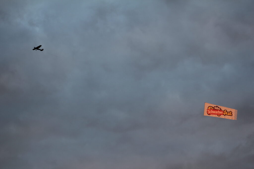 A plane flies a banner that reads 