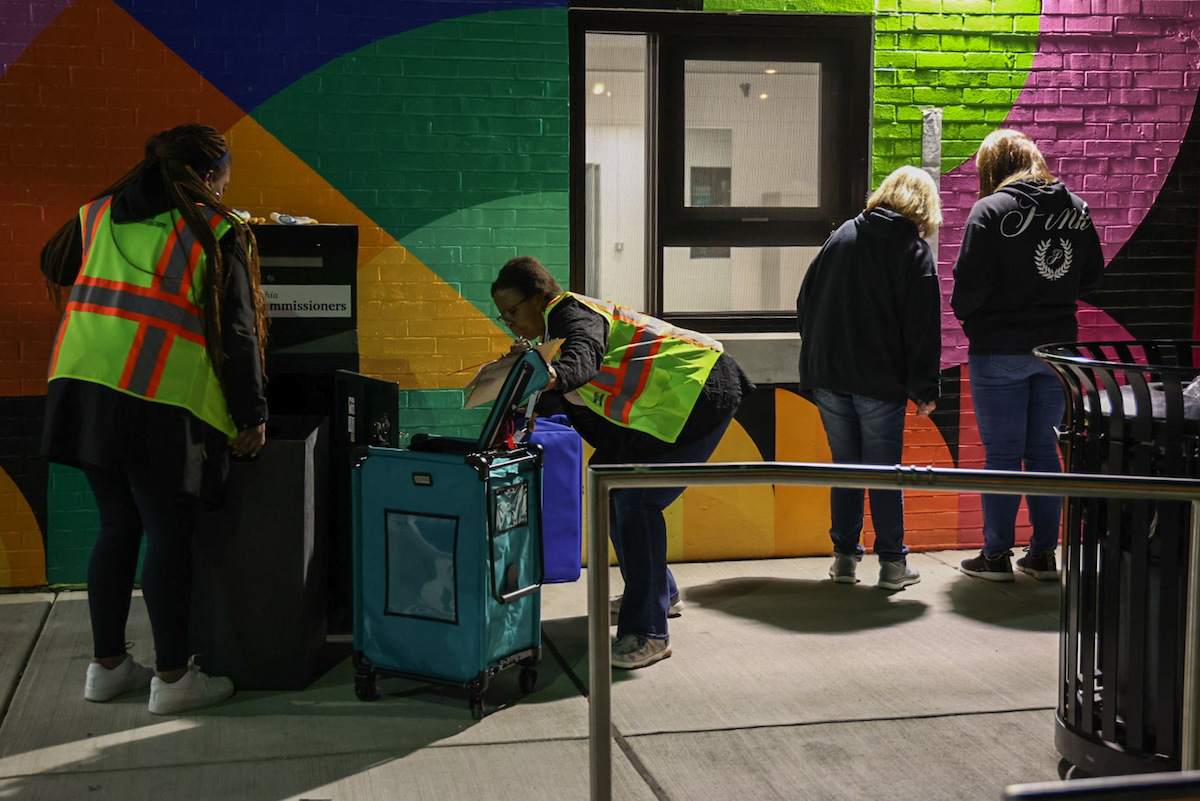 Workers from the Philadelphia City Commissioner’s transfer mail-in ballots