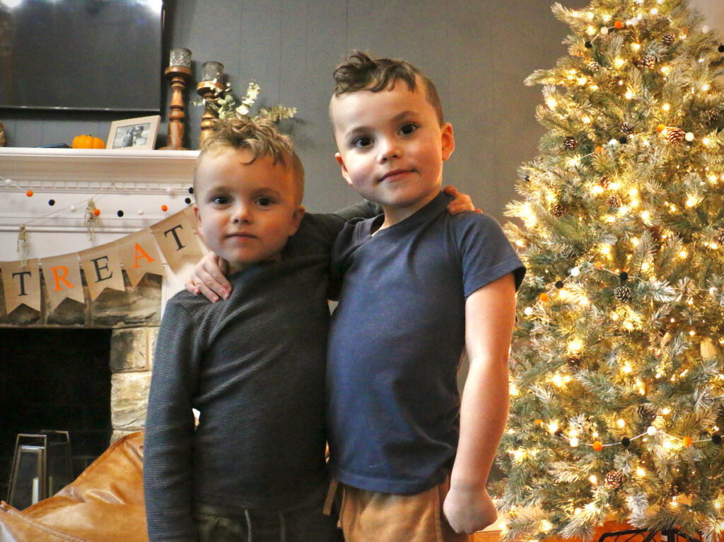 Cash Huber, 6, (right) poses with his younger brother, Stone, in the family living room in Wilmington. (Emma Lee/WHYY)