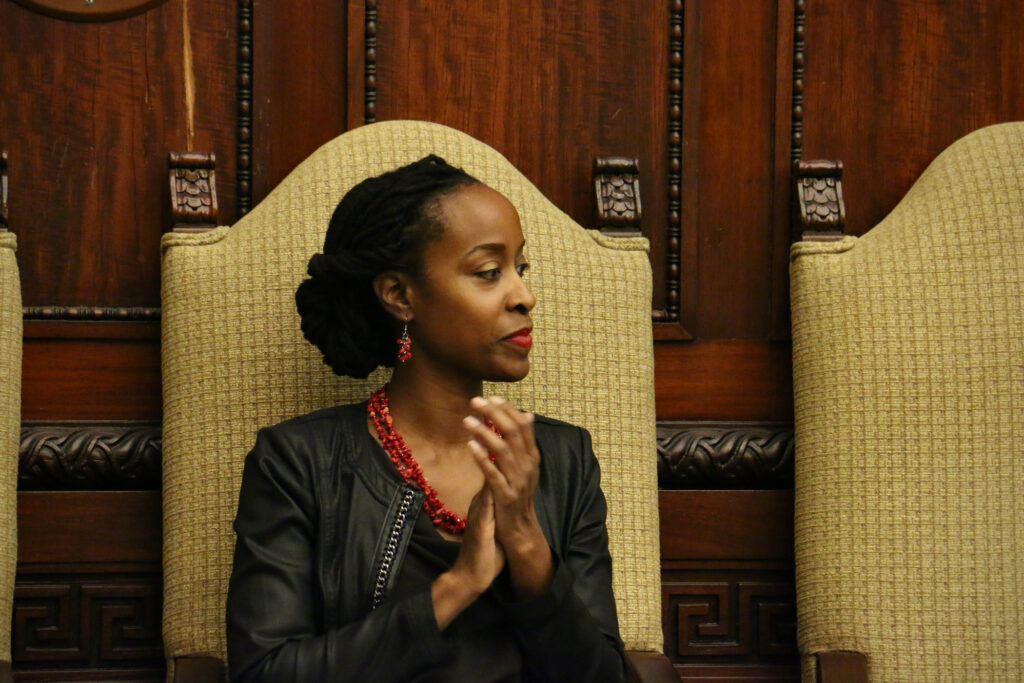 Marguerite Anglin claps her hands as she sits at City Hall