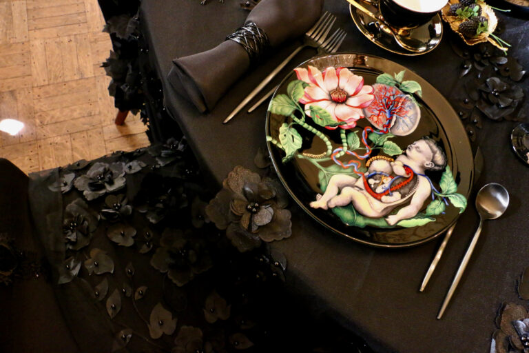 A plate showing a child is set on a black lace table cloth