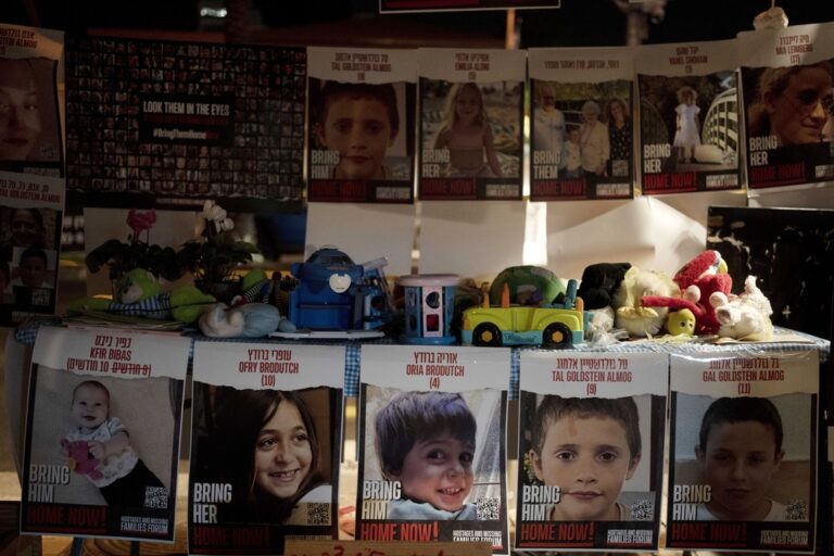 Posters of children held hostage by Hamas in the Gaza Strip are displayed with toys