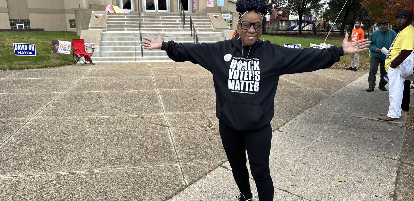 A voter outstretches their arms in front of their polling station