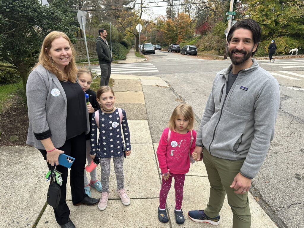 A family poses for a photo outside their polling place