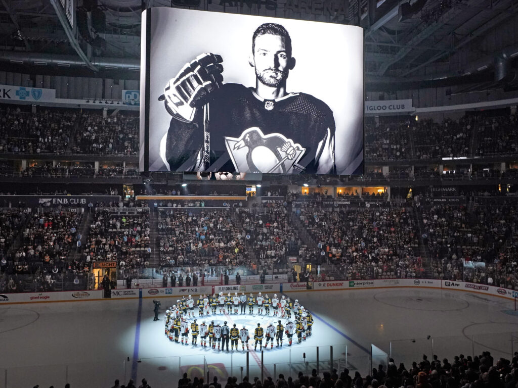Players from the Pittsburgh Penguins and Anaheim Ducks on Monday honored former Penguin player Adam Johnson, who died during a game in England. The Penguins are making neck guards mandatory for players at the minor-league level, and will also urge NHL players to wear them. Players from the Pittsburgh Penguins and Anaheim Ducks on Monday honored former Penguin player Adam Johnson, who died during a game in England. The Penguins are making neck guards mandatory for players at the minor-league level, and will also urge NHL players to wear them.