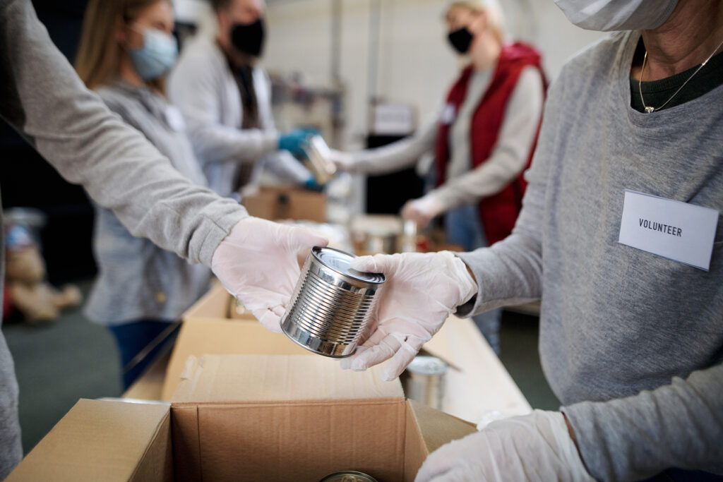 Group Of Volunteers In Community Donation Center, Food Bank And Volunteers at a food bank