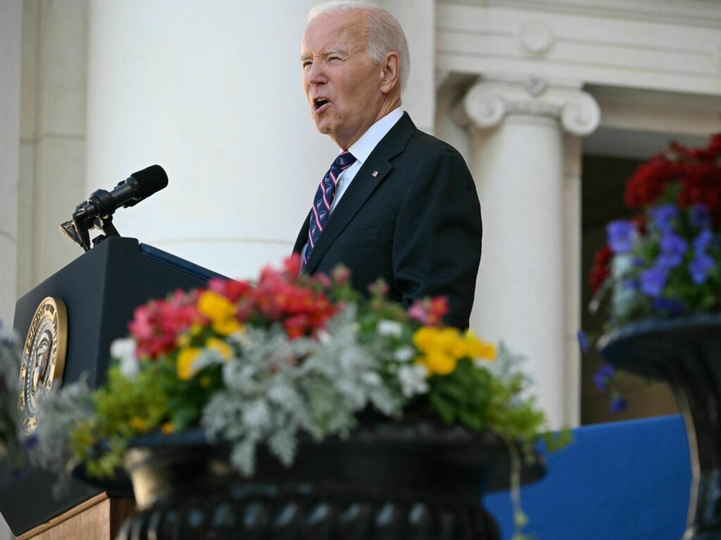 President Biden speaks at the Memorial Amphitheater in Arlington National Cemetery during celebrations for Veterans Day on Saturday in Arlington, Virginia. Biden speaks at a podium.