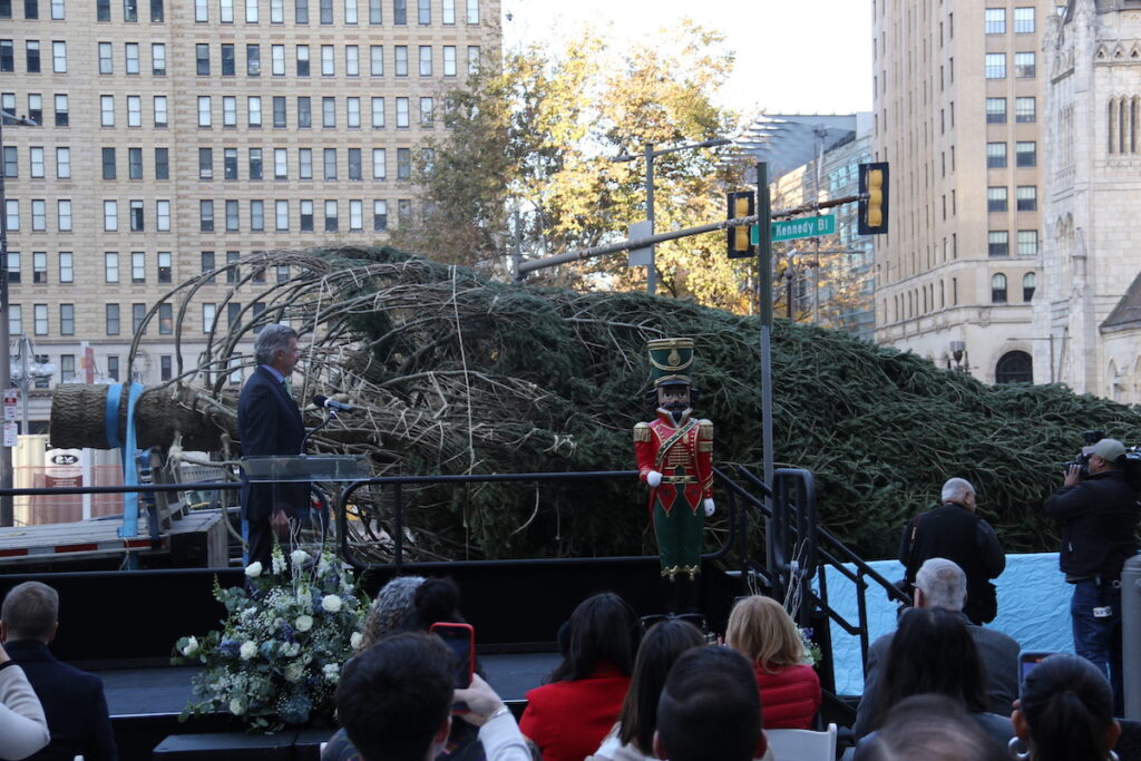 philadelphia-tree-1 A tree is visible laid on its side in front of a crowd of people outside.