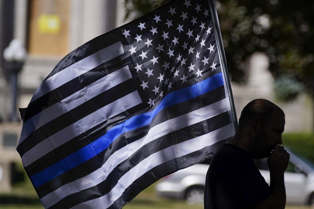 Police Flag Lawsuit A person carries a flag with a thin blue line, also known as a