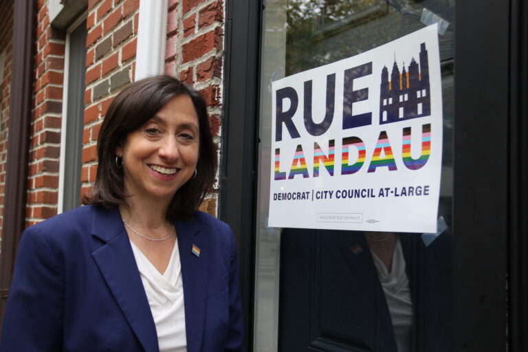 Rue Landau posing in front of her campaign sign.