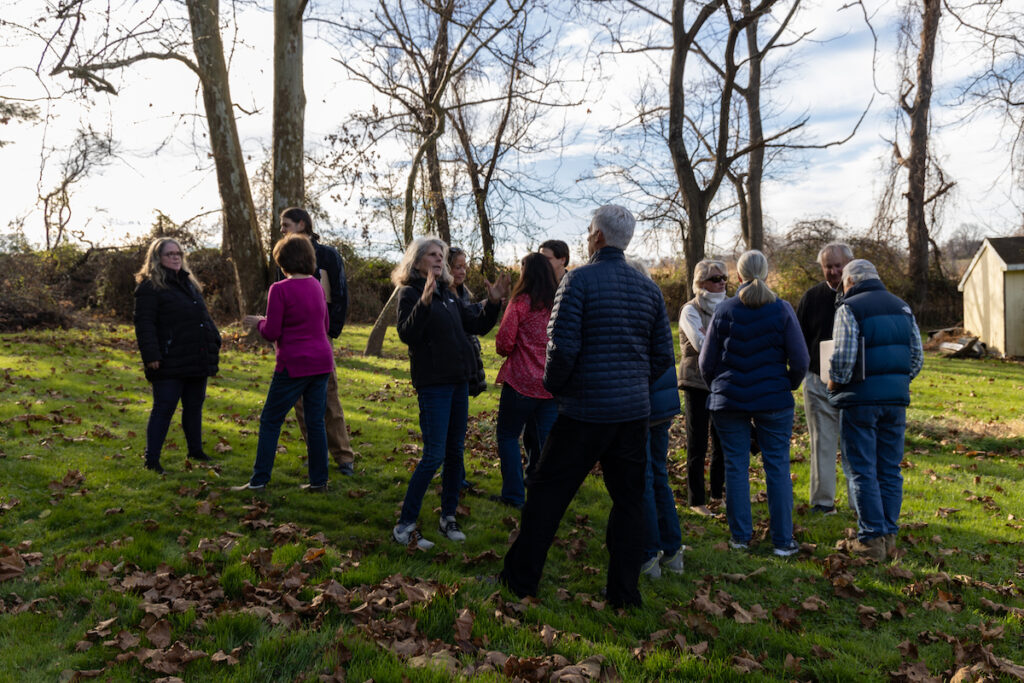 People gather together in a field outdoors.