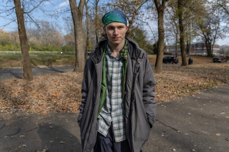 A young man poses for a photo outdoors