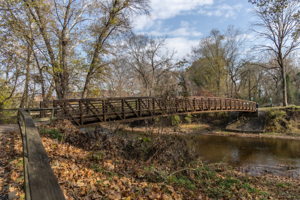 The Schuylkill River Trail in Pottstown, Pa. (Kimberly Paynter/WHYY) A small bridge goes over the stream.