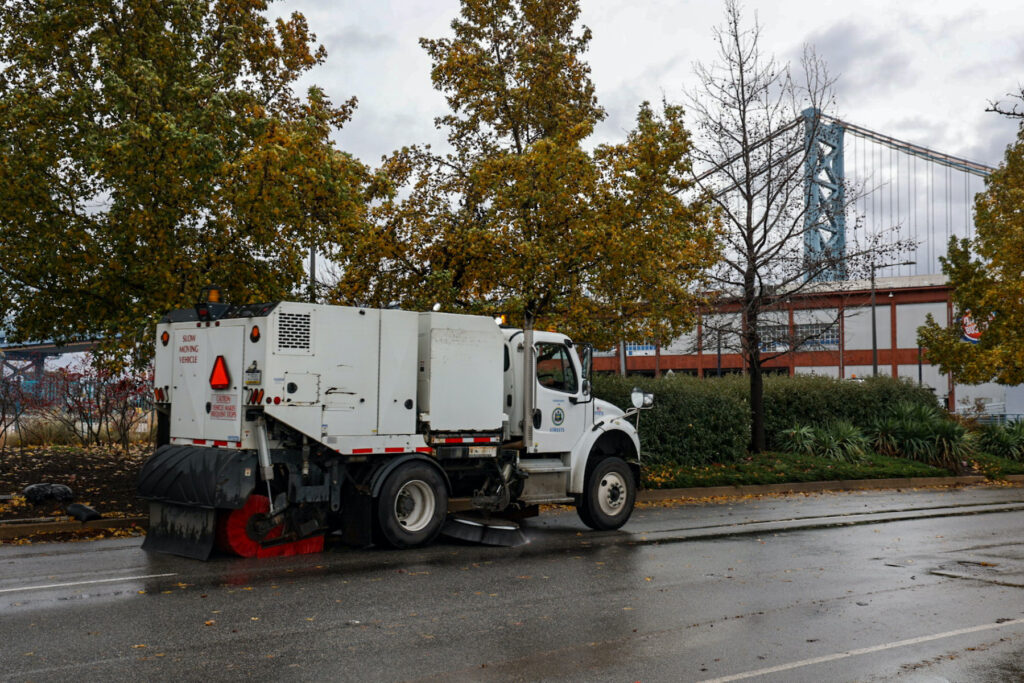 12 18 2023 kpaynter dekaware river flooding post storm-2 Philadelphia street sweeping vehicles worked to clear debris from Columbus Blvd. after a storm brought heavy rain to the region and the Delaware River overflowed onto the road on December 18, 2023. (Kimberly Paynter/WHYY)
