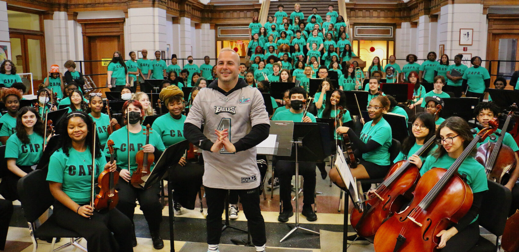 Yannick Nézet-Séguin posing with high school orchestra members